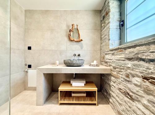 a bathroom with a sink and a stone wall at Agnandio Retreat Euboea in Animborió