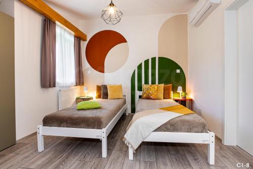 a bedroom with two beds and a chandelier at KORZO LIPNO C in Lipno nad Vltavou