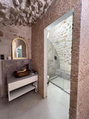 a bathroom with a shower and a sink and a mirror at Konak Zenobia in Midyat