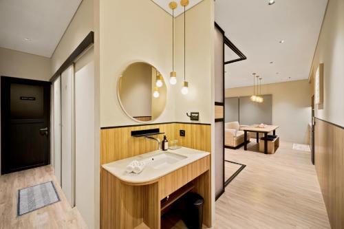 a bathroom with a sink and a mirror at Oku Suites Bandung in Bandung