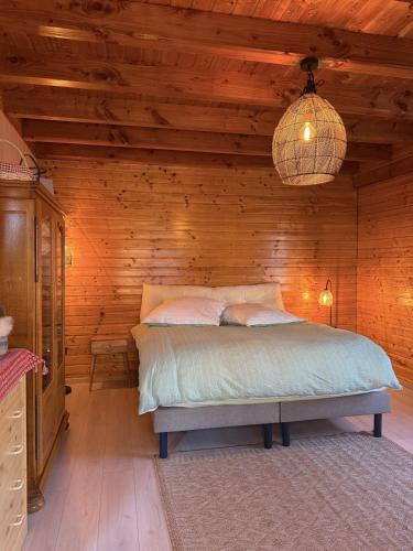 a bedroom with a bed in a wooden cabin at Le Chalet Hubertus - Climatisé - 80 m2 in Rohrbach-lès-Bitche