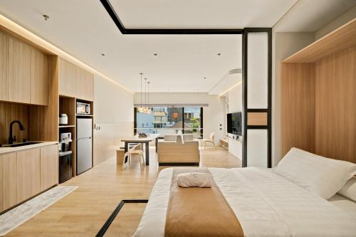 a bedroom with a large bed and a kitchen at Oku Suites Bandung in Bandung