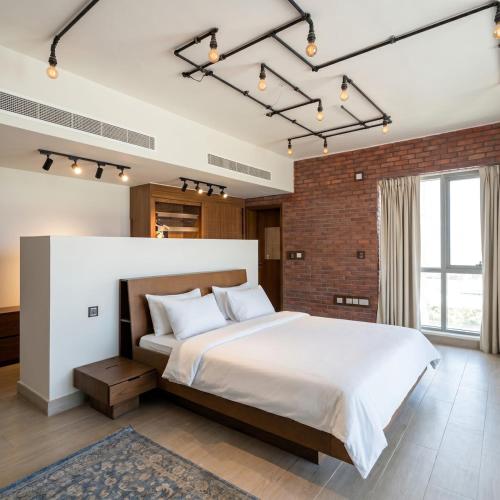 a bedroom with a large bed and a brick wall at Sifa Golf Lake in Muscat