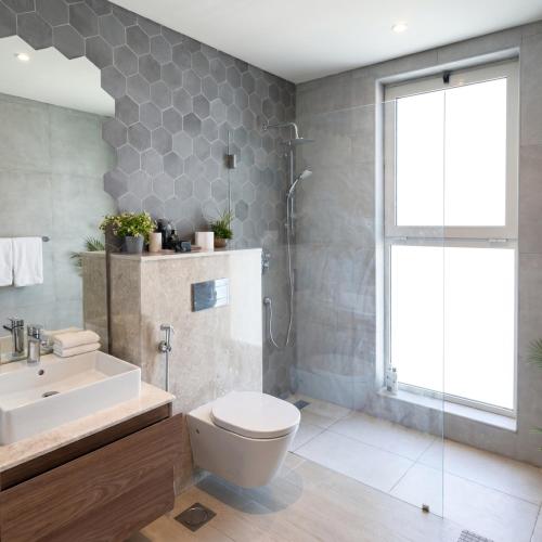 a bathroom with a toilet and a sink and a shower at Sifa Golf Lake in Muscat