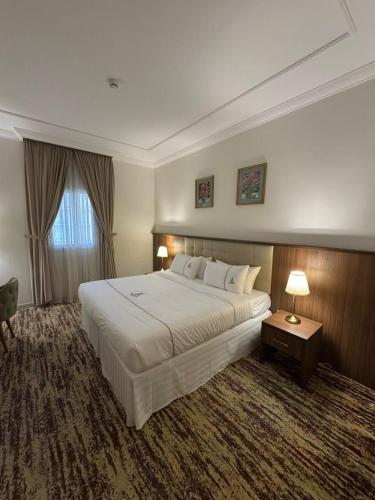 a hotel room with a large bed and a window at فندق مزايا in Az Zāhir