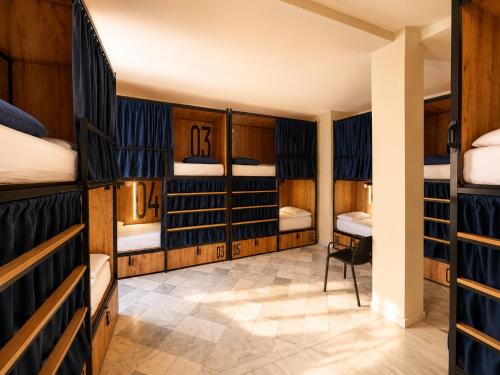 a room with three bunk beds and a hallway at JOY Plaza de Armas in Seville