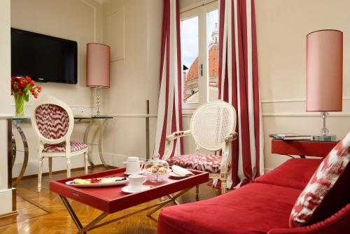 a living room with a red couch and chairs at Brunelleschi Hotel in Florence
