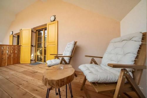 a living room with two chairs and a table at Hiša Tam Čez in Slovenj Gradec