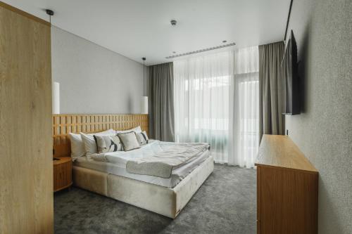 a bedroom with a bed and a large window at Fomich Estates in Bukovel