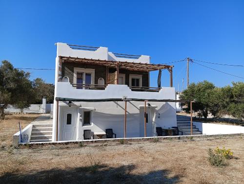 a white house with a porch and stairs at Countryside Retreat 4 in Agios Arsenios