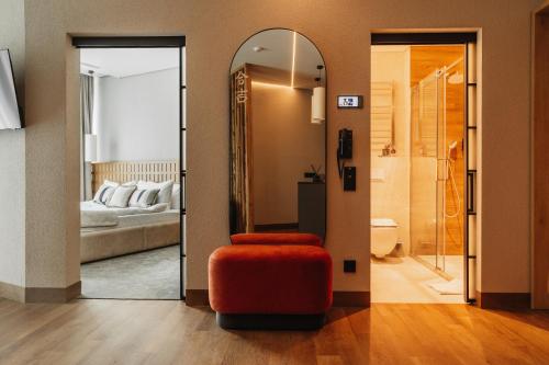 a room with a mirror and a red ottoman and a bedroom at Fomich Estates in Bukovel