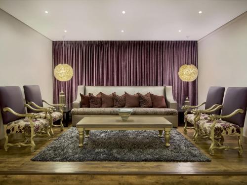 ein Wohnzimmer mit Sofa und Tisch in der Unterkunft ANEW Hotel Hatfield Pretoria in Pretoria