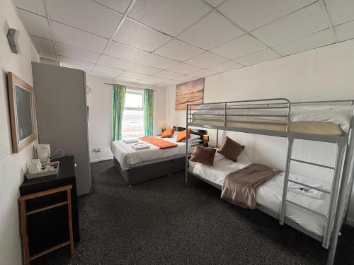 a room with two bunk beds and a television at The Jack Sparrow Hotel in Blackpool