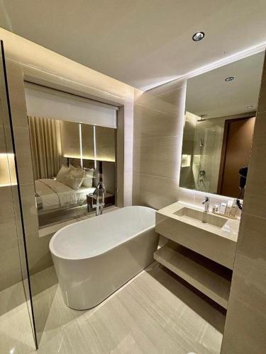 a bathroom with a tub and a sink and a bed at فندق سدو بوتيك التحلية in Medina