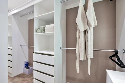 a walk in closet with white cabinets and towels at Lakeside Serenity in Hindmarsh Island