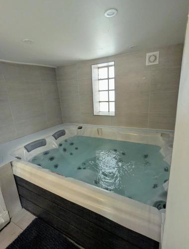 a jacuzzi tub in a bathroom with a window at Maison hyper centre Jacuzzi in Amboise
