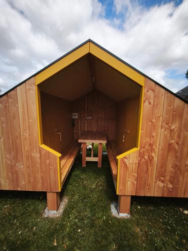 a large wooden building with a picnic table in it at Camping Kerlaudy La pause Atypi'k in Plouénan