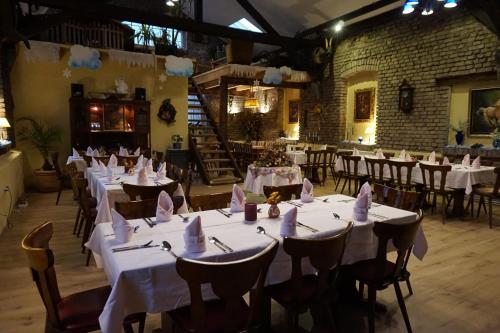a dining room with tables and chairs with white tablecloths at Thüringer Hof in Heringen