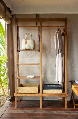 a wooden shelf with a coat and a purse at ARNA Suites and Ocean Lounge in Nusa Lembongan