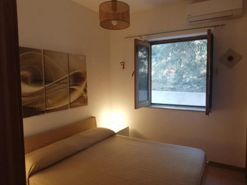 a bedroom with a bed and a window at Da Riccardo in Malfa