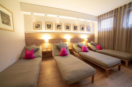 a living room with couches and pink pillows at Papagenoblick in Filzmoos