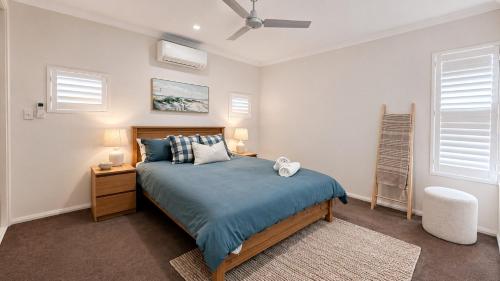 a bedroom with a bed with a blue comforter at Saltwater Stay in Bunbury