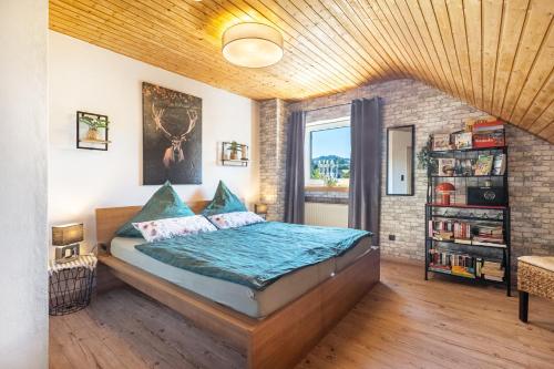 a bedroom with a bed with a wooden ceiling at Ferienwohnung an der Bieke in Olsberg