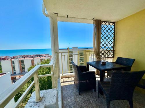 a balcony with a table and chairs and a view of the ocean at Cozy Corner Studio in Crown Fort in Sveti Vlas