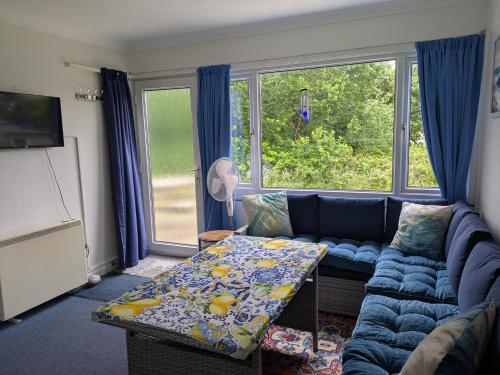 a living room with a blue couch and a table at 21 The Glade in Bude