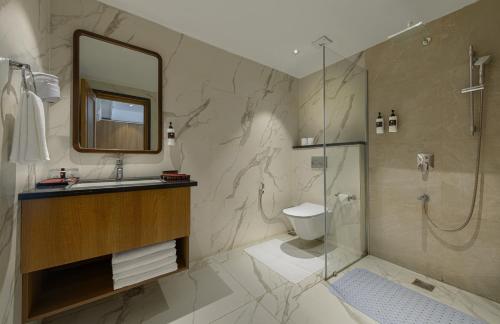 a bathroom with a shower and a sink and a mirror at Ginger Rishikesh, Dehradun Road in Rishīkesh