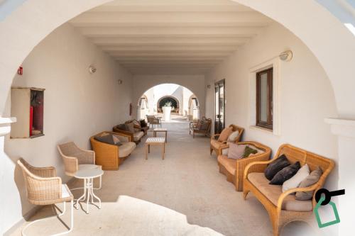 a living room with couches and chairs and an archway at Hotiday Fasano Mare in Savelletri di Fasano