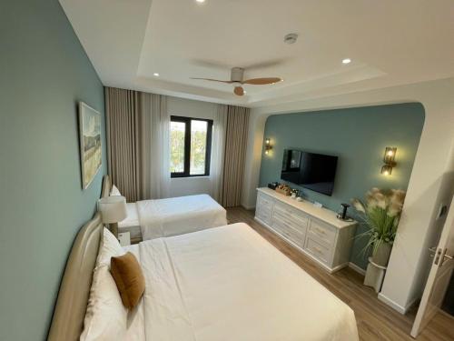 a hotel room with two beds and a television at Ocean Homes cơ sở SH24 in Ðình Loan