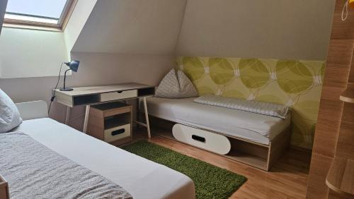 ein kleines Zimmer mit zwei Betten und einem Schreibtisch in der Unterkunft Elizabet in Bojnice