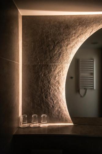two glasses sitting on a counter in front of a mirror at Arche Hotel Lotnisko Gdańsk in Gdańsk-Rębiechowo