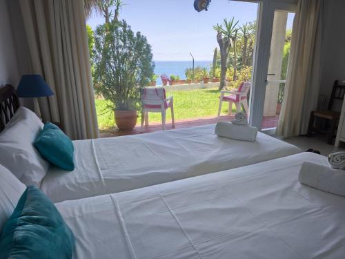 a bedroom with two beds and a view of the ocean at Calma Bungalow 54b en Urbanización La Roca in Torremolinos