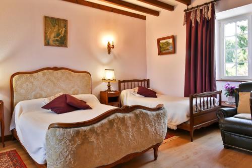 a living room with two beds and a couch at Manoir De Labelangerie in Acqueville