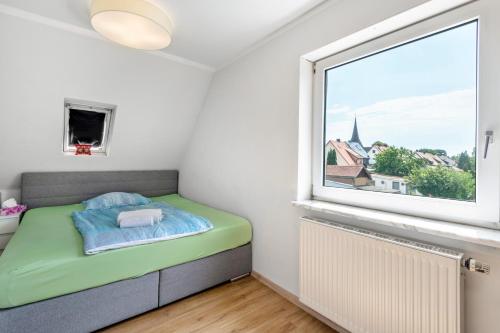 a small bedroom with a bed and a window at Geräumiges Haus mit Garten Terasse in Nuremberg