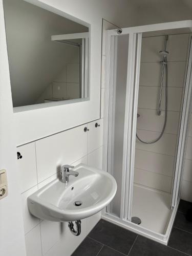 a white bathroom with a sink and a shower at Hochwertige Monteurunterkunft in Zarrentin
