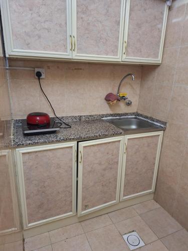 eine Küche mit Spüle und Arbeitsplatte in der Unterkunft Ur place in al-Ain