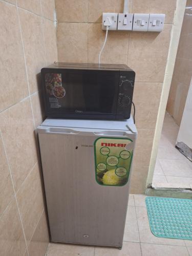 eine Mikrowelle, die auf einem Kühlschrank steht in der Unterkunft Ur place in al-Ain