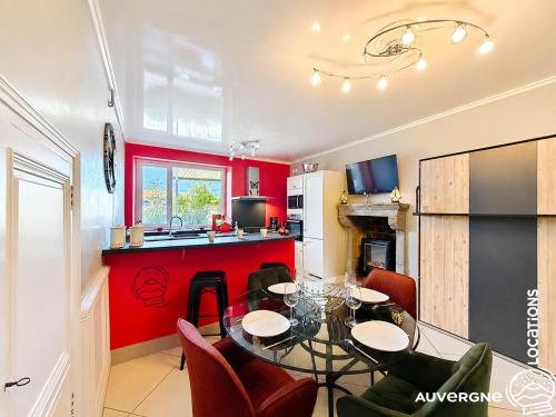 a kitchen and living room with a table and chairs at Le Chardonneret du Sancy in Montaigut-le-Blanc
