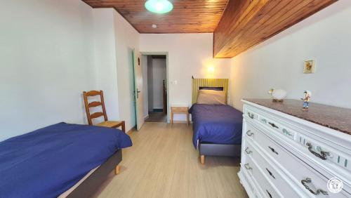 a bedroom with a bed and a dresser with a desk at Chez l'tiote morvandelle in Montigny-en-Morvan