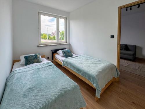 two beds in a room with a mirror at Apartamenty Piotrowice in Piotrowice