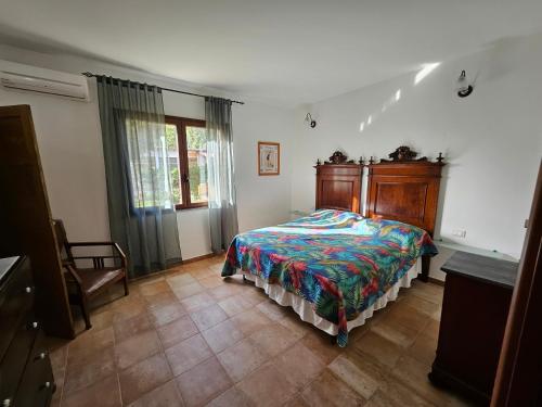 ein Schlafzimmer mit einem Bett mit hölzernem Kopfteil in der Unterkunft Masone Verde in Castiadas