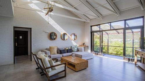 a living room with a couch and a table at Sunset Bay Stay in Hout Bay