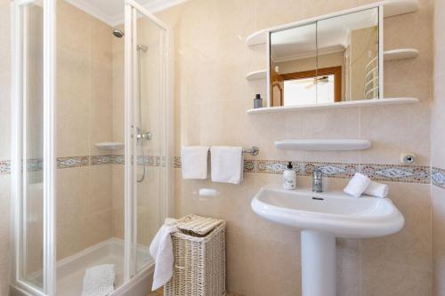 a bathroom with a sink and a shower and a mirror at Floridamar Mimosa in Jávea