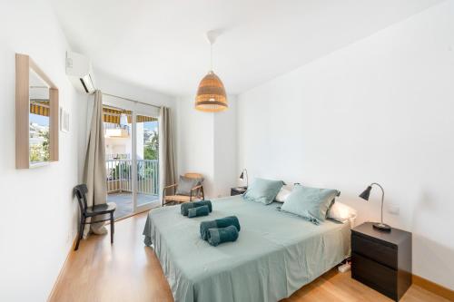 a bedroom with a large bed with blue pillows on it at Apartment Overlooking the Beach in Marbella