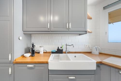 a kitchen with a white sink and wooden counter top at Apartment Overlooking the Beach in Marbella
