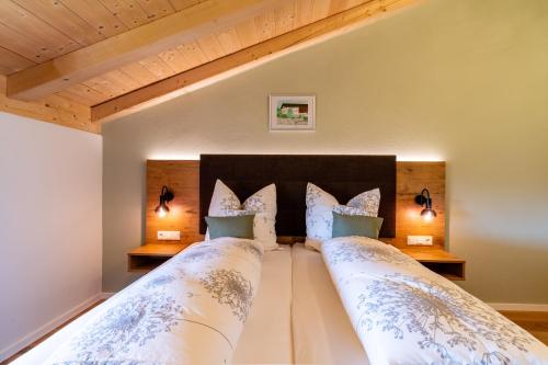 a bedroom with a large bed with two pillows at Ferienwohnungen Schmiedhof in Eggstätt