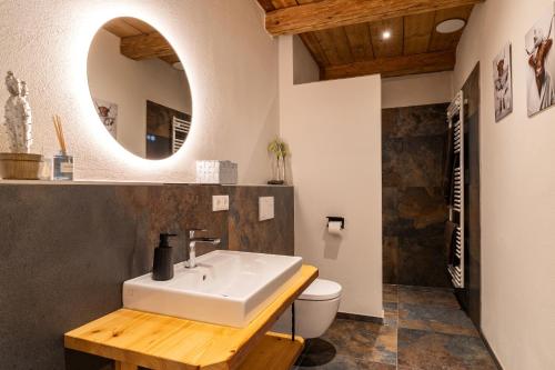 a bathroom with a sink and a toilet and a mirror at Ferienwohnungen Schmiedhof in Eggstätt